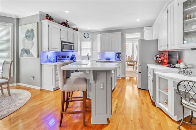 8007 W 131st Ter, Overland Park, KS 66213 - kitchen featuring stainless steel appliances, ornamental molding, a kitchen breakfast bar, light countertops, and a kitchen island