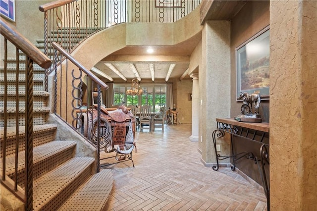 12635 W 183rd St, Overland Park, KS 66013 - staircase featuring a textured wall, a chandelier, and a high ceiling
