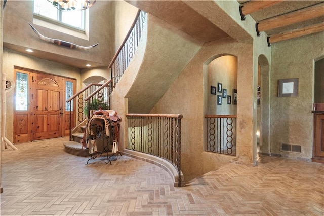 12635 W 183rd St, Overland Park, KS 66013 - entryway with arched walkways, stairway, a high ceiling, a chandelier, and beamed ceiling