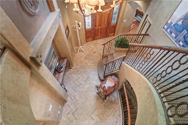 12635 W 183rd St, Overland Park, KS 66013 - living room featuring arched walkways, a chandelier, a textured wall, and a towering ceiling