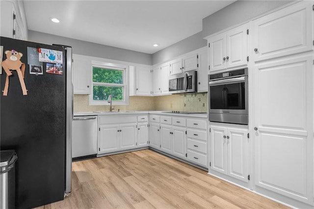 39103 New Lancaster Rd, Lacygne, KS 66040 - kitchen with stainless steel appliances, light wood finished floors, tasteful backsplash, white cabinets, and light countertops