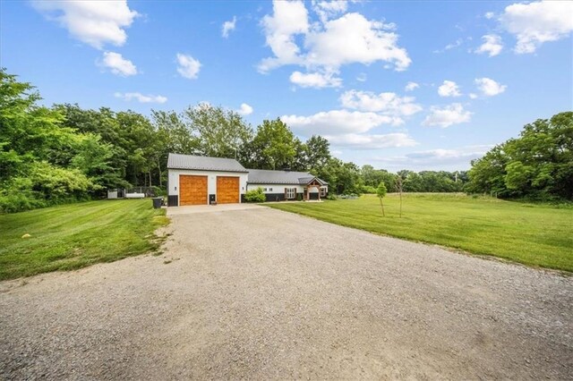 6401 SE Hamilton Rd, Holt, MO 64048 - view of front of house featuring gravel driveway, a front yard, an attached garage, and a metal roof