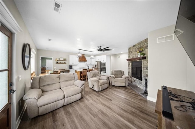 6401 SE Hamilton Rd, Holt, MO 64048 - living area with a stone fireplace, wood finished floors, and ceiling fan