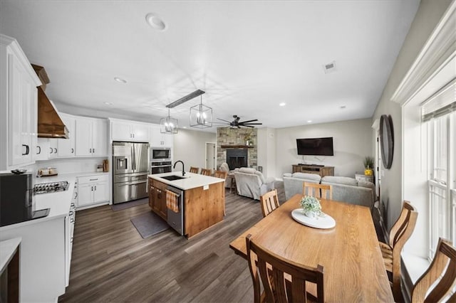 6401 SE Hamilton Rd, Holt, MO 64048 - dining space with a fireplace, dark wood-style floors, ceiling fan, and recessed lighting