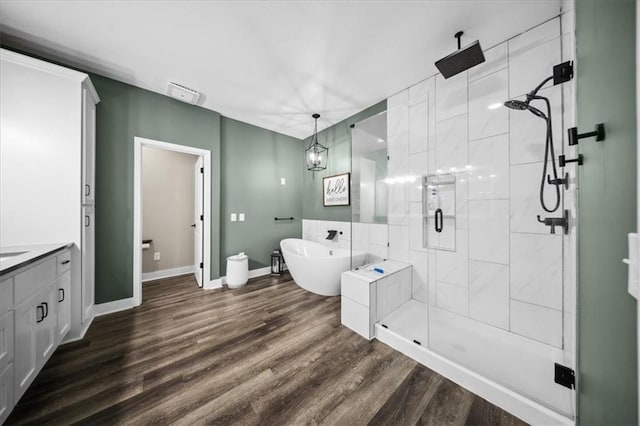 6401 SE Hamilton Rd, Holt, MO 64048 - full bathroom featuring a shower stall, a freestanding tub, vanity, and wood finished floors
