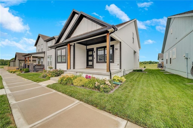 23506 E 10th St S, Independence, MO 64056 - view of front of property with covered porch, board and batten siding, and a front lawn