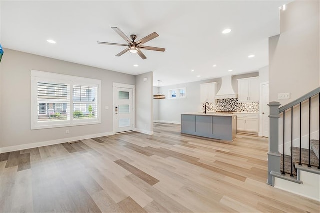 23506 E 10th St S, Independence, MO 64056 - unfurnished living room with light wood-style floors, ceiling fan, stairway, and recessed lighting