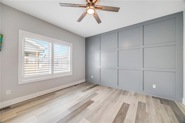 23506 E 10th St S, Independence, MO 64056 - unfurnished bedroom with light wood-style flooring, a ceiling fan, and a decorative wall