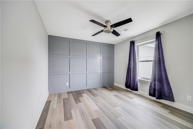 23506 E 10th St S, Independence, MO 64056 - unfurnished bedroom featuring a decorative wall, light wood finished floors, and a ceiling fan