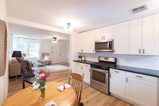319 E 12th St, Ottawa, KS 66067 - kitchen featuring appliances with stainless steel finishes, light wood-type flooring, and backsplash