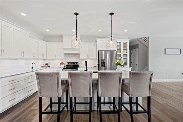 6417 County Road 10508th Rd, Rich Hill, MO 64779 - kitchen featuring stainless steel appliances, backsplash, white cabinetry, a center island with sink, and a breakfast bar area