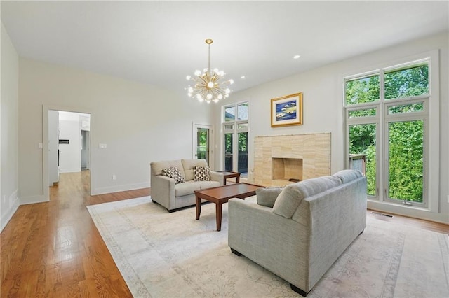 6112 N Mattox Rd, Kansas City, MO 64151 - living area with light wood-style flooring, a chandelier, and a fireplace