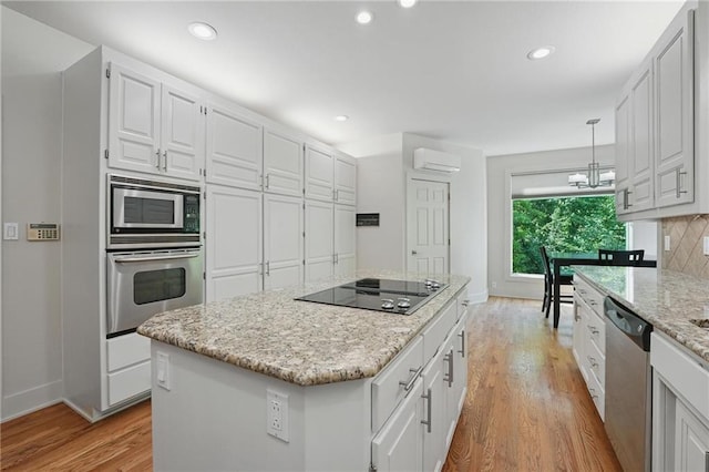 6112 N Mattox Rd, Kansas City, MO 64151 - kitchen with appliances with stainless steel finishes, a wall mounted AC, light wood-style floors, white cabinetry, and recessed lighting