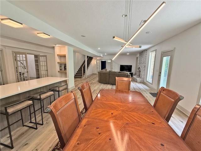 6112 N Mattox Rd, Kansas City, MO 64151 - dining area with light wood finished floors, stairway, recessed lighting, a fireplace, and built in features