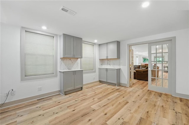 6112 N Mattox Rd, Kansas City, MO 64151 - kitchen with gray cabinets, light wood-style flooring, backsplash, recessed lighting, and light countertops