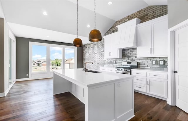 6045 Apache Dr, Shawnee, KS 66226 - kitchen featuring stainless steel range with gas cooktop, vaulted ceiling, custom range hood, a center island with sink, and light countertops