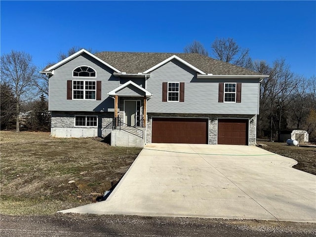 318 NE 51st Rd, Warrensburg, MO 64093 - raised ranch featuring an attached garage, concrete driveway, stone siding, and a shingled roof