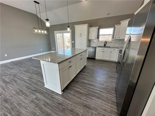 318 NE 51st Rd, Warrensburg, MO 64093 - kitchen featuring appliances with stainless steel finishes, vaulted ceiling, plenty of natural light, white cabinetry, and a center island