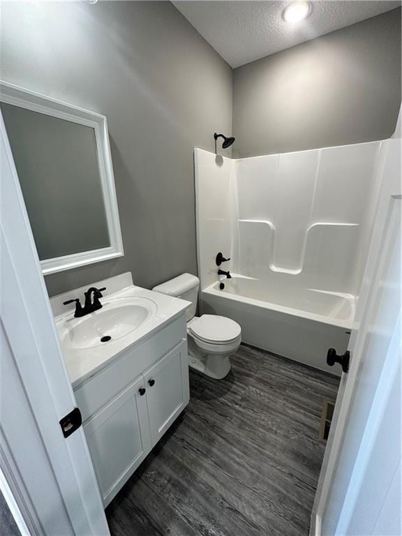 318 NE 51st Rd, Warrensburg, MO 64093 - bathroom featuring a textured ceiling, vanity, shower / washtub combination, and wood finished floors