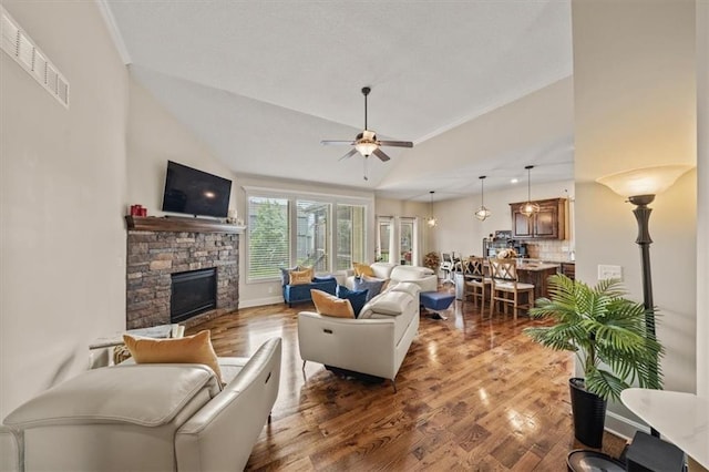 18783 W 165th St, Olathe, KS 66062 - living room featuring a ceiling fan, a fireplace, wood finished floors, and vaulted ceiling