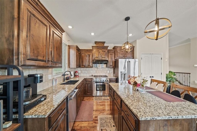 18783 W 165th St, Olathe, KS 66062 - kitchen featuring high quality appliances, light wood-style flooring, a center island, tasteful backsplash, and light stone counters