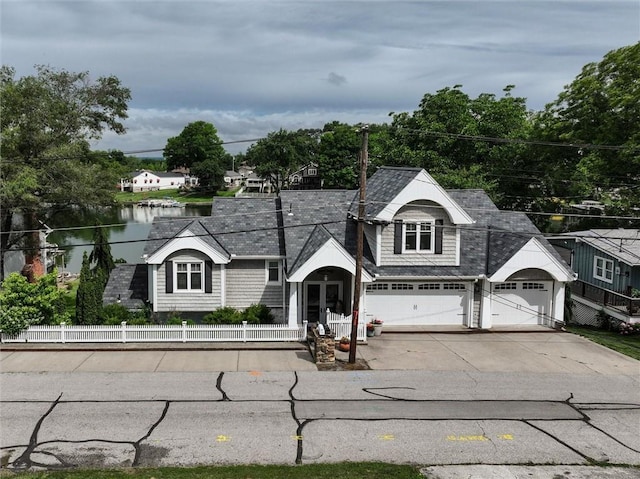 11 Dockside Dr, Lake Tapawingo, MO 64015 - view of front of property with a fenced front yard, driveway, a water view, and a garage