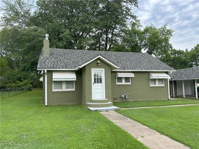 1047 N Lynn St, Nevada, MO 64772 - bungalow-style house with brick siding, a chimney, entry steps, and roof with shingles