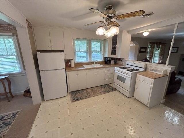 1047 N Lynn St, Nevada, MO 64772 - kitchen with white appliances, ceiling fan, white cabinets, a peninsula, and light floors