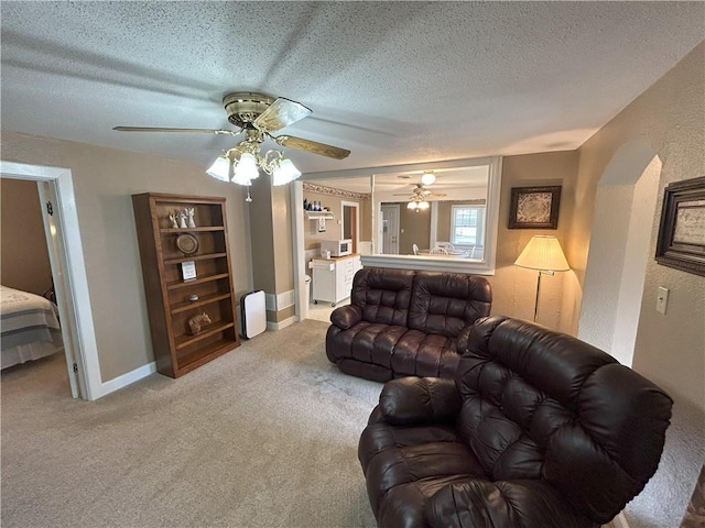1047 N Lynn St, Nevada, MO 64772 - living room with a textured ceiling, carpet, a ceiling fan, and a textured wall