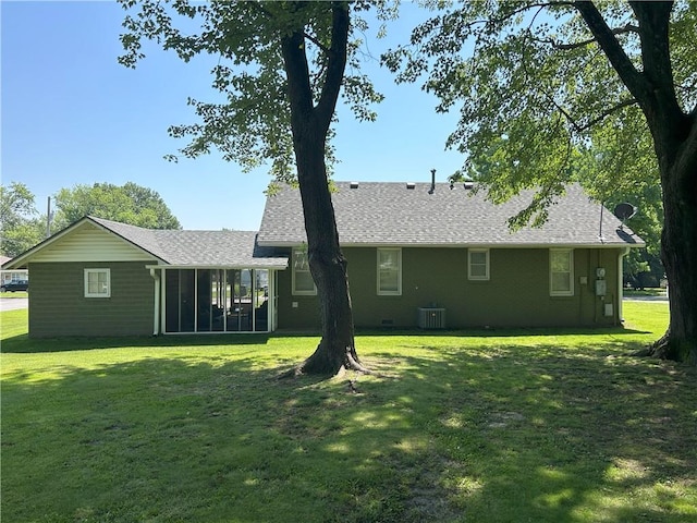 1047 N Lynn St, Nevada, MO 64772 - rear view of house featuring a sunroom, a yard, and roof with shingles