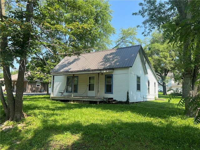 229 E Bates St, Drexel, MO 64742 - back of property with covered porch, a yard, and a metal roof