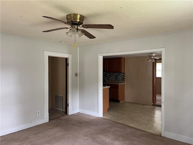229 E Bates St, Drexel, MO 64742 - unfurnished room with ceiling fan, light colored carpet, and wood walls