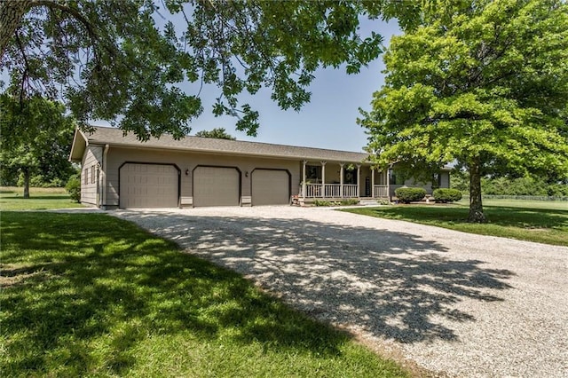 2450 Labette Rd, Ottawa, KS 66067 - single story home with an attached garage, driveway, a porch, and a front lawn