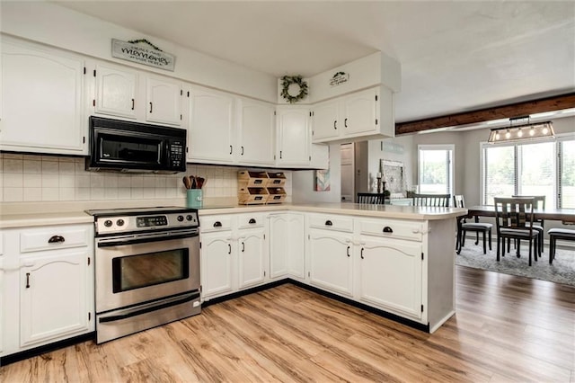 2450 Labette Rd, Ottawa, KS 66067 - kitchen with electric range, black microwave, light wood-style floors, white cabinetry, and a peninsula