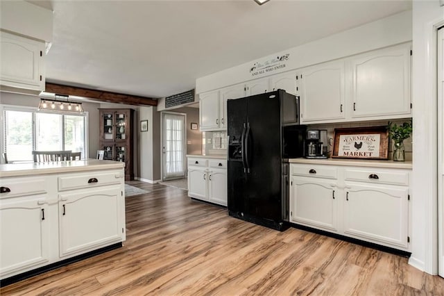 2450 Labette Rd, Ottawa, KS 66067 - kitchen with black fridge, light wood-style flooring, white cabinets, and light countertops