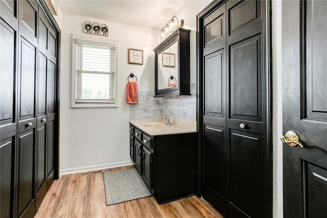 2450 Labette Rd, Ottawa, KS 66067 - bathroom with a closet, vanity, wood finished floors, and tasteful backsplash