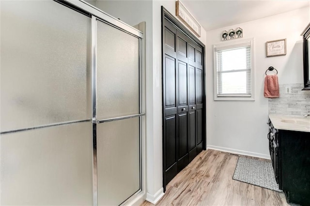 2450 Labette Rd, Ottawa, KS 66067 - full bath with vanity, wood finished floors, and a stall shower