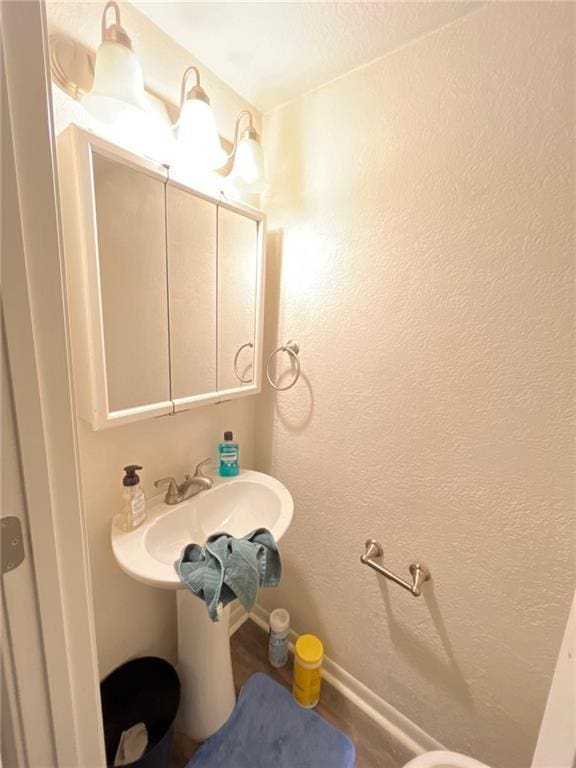 2122 S Scott Ave, Independence, MO 64052 - half bathroom with a sink and wood finished floors