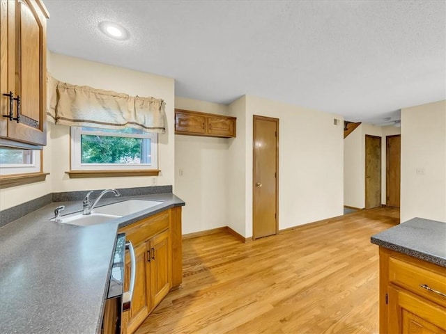 15409 Conser St, Overland Park, KS 66223 - kitchen with dark countertops, brown cabinetry, light wood-style floors, a textured ceiling, and recessed lighting