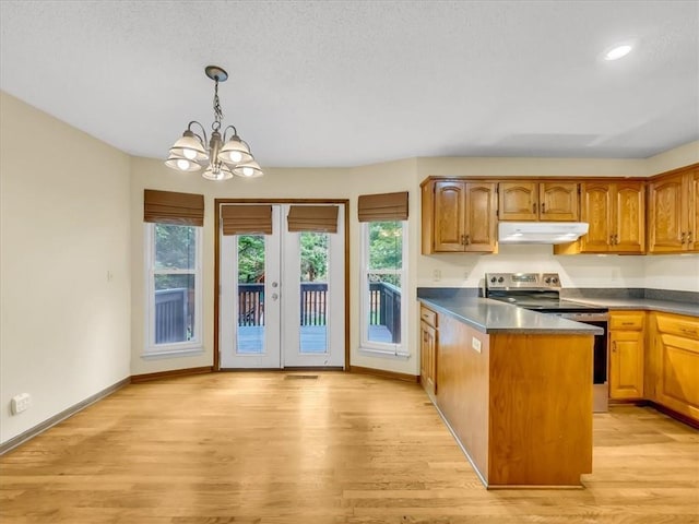 15409 Conser St, Overland Park, KS 66223 - kitchen featuring stainless steel electric stove, under cabinet range hood, a peninsula, a chandelier, and light wood-style floors