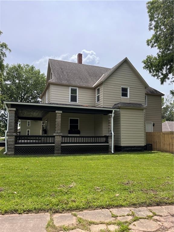 112 N High St, Butler, MO 64730 - view of front of home with a chimney and a porch