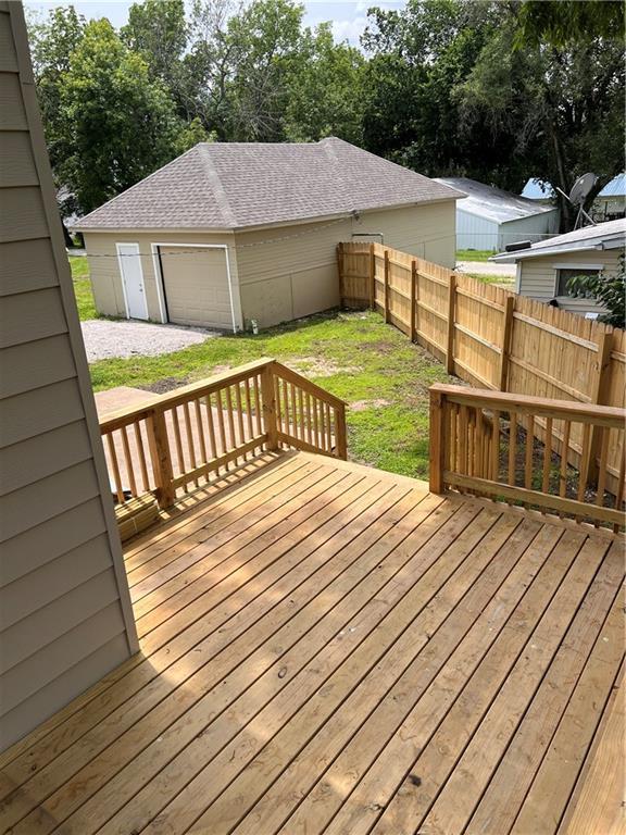 112 N High St, Butler, MO 64730 - wooden deck with an outdoor structure and a detached garage