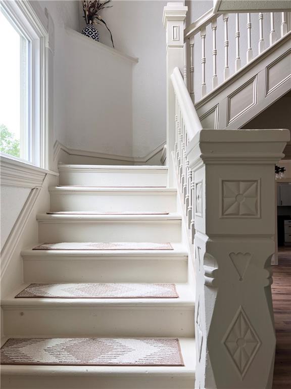 112 N High St, Butler, MO 64730 - staircase featuring wood finished floors
