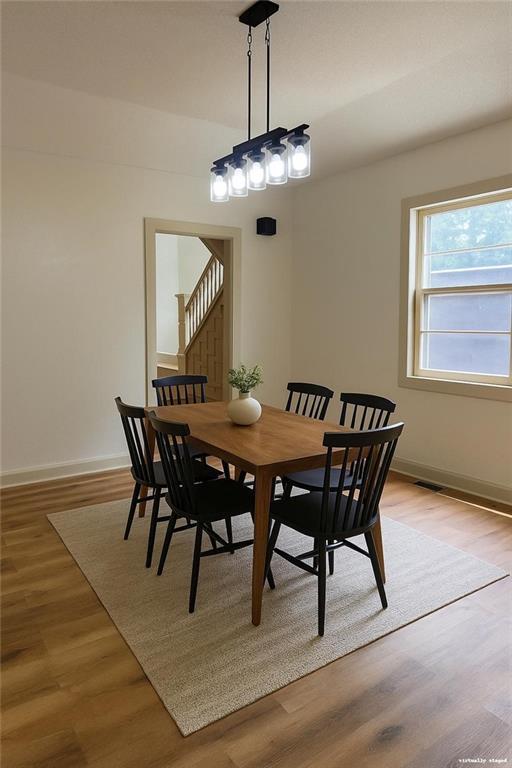112 N High St, Butler, MO 64730 - dining space featuring light wood-type flooring and stairs