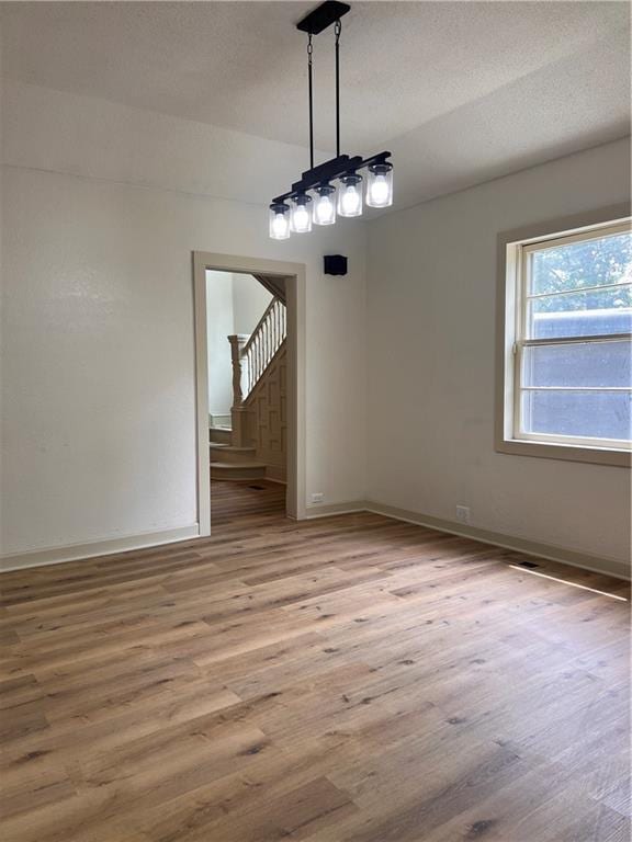 112 N High St, Butler, MO 64730 - unfurnished dining area with stairway and light wood finished floors