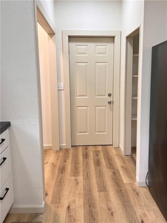 112 N High St, Butler, MO 64730 - entryway featuring light wood-type flooring and a textured wall