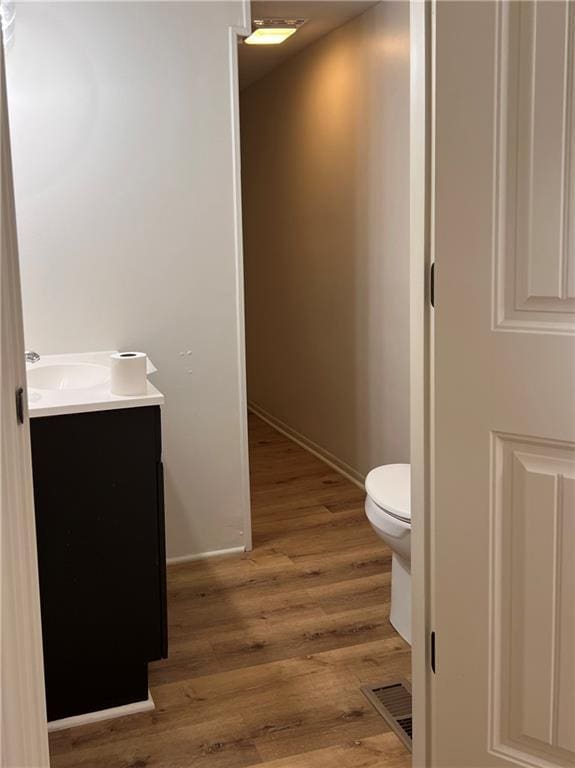 112 N High St, Butler, MO 64730 - half bath with vanity and wood finished floors