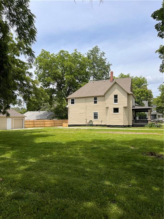 112 N High St, Butler, MO 64730 - back of property with a chimney and a garage