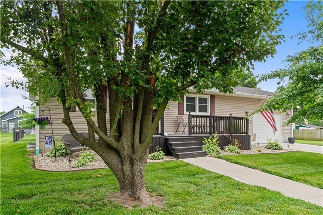 505 S Magdalena St, Concordia, MO 64020 - obstructed view of property with a front yard, an attached garage, concrete driveway, and a deck