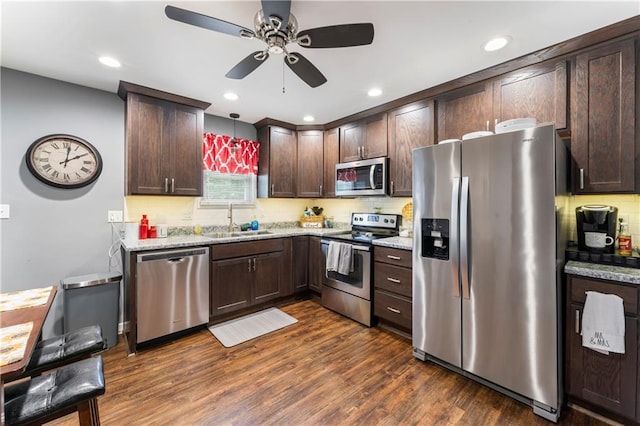505 S Magdalena St, Concordia, MO 64020 - kitchen featuring appliances with stainless steel finishes, dark brown cabinets, ceiling fan, backsplash, and dark wood-style flooring